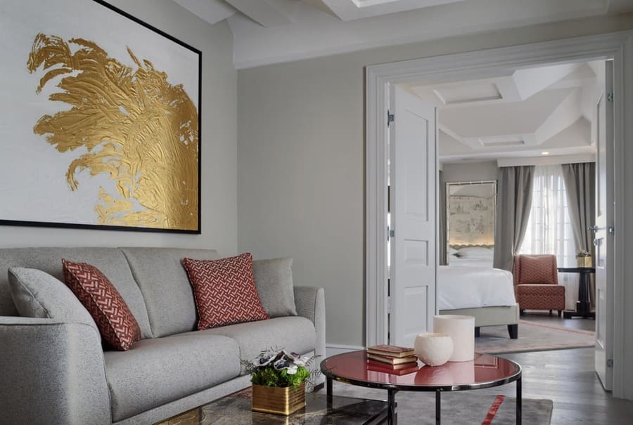 Gold and red details on a neutral-toned palette was the choice for this luxurious and modern living room, perfect for a family house!